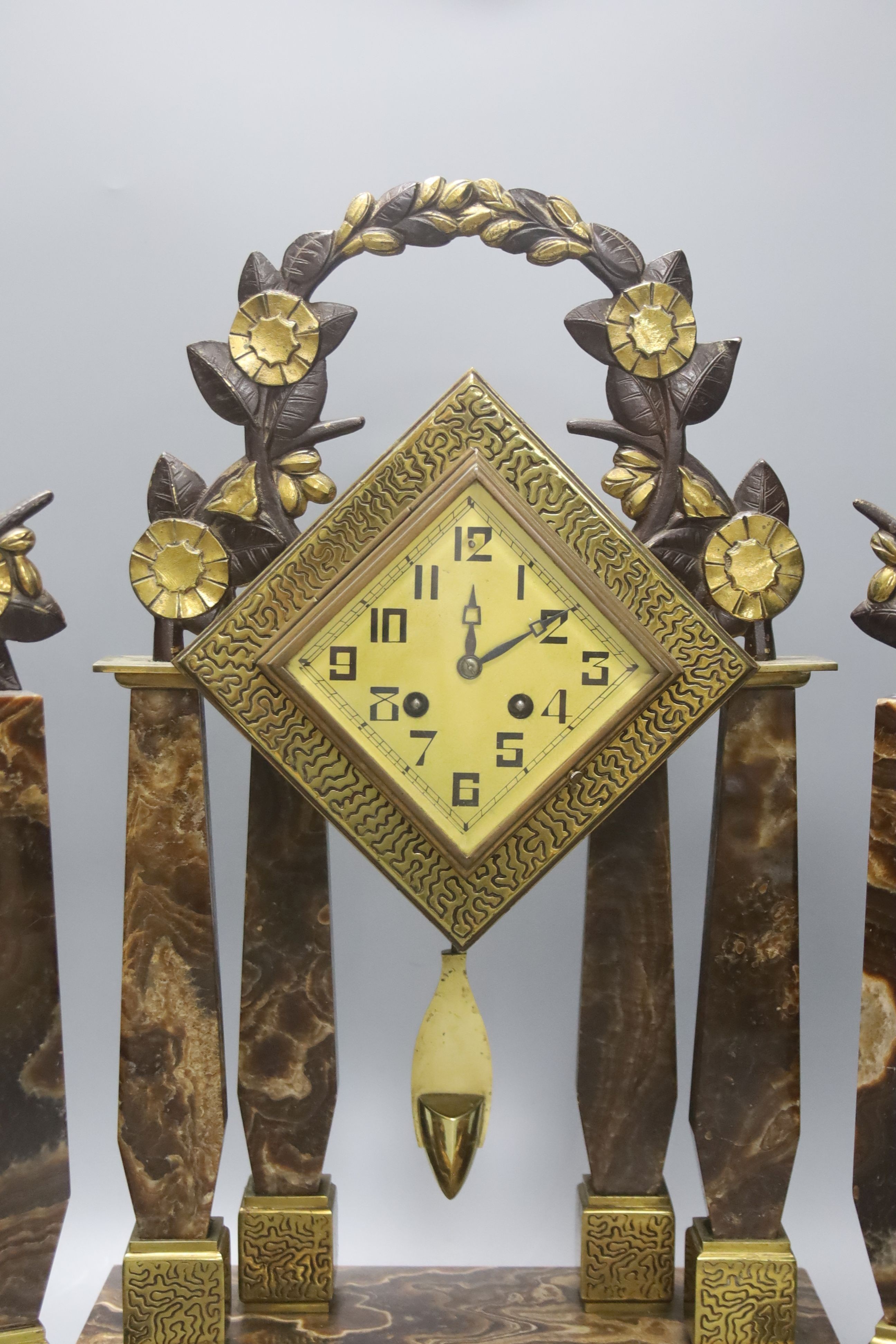 An Art Deco Brazilian onyx clock garniture, Marti movement countwheel striking on a bell, stamped, clock height 48cm